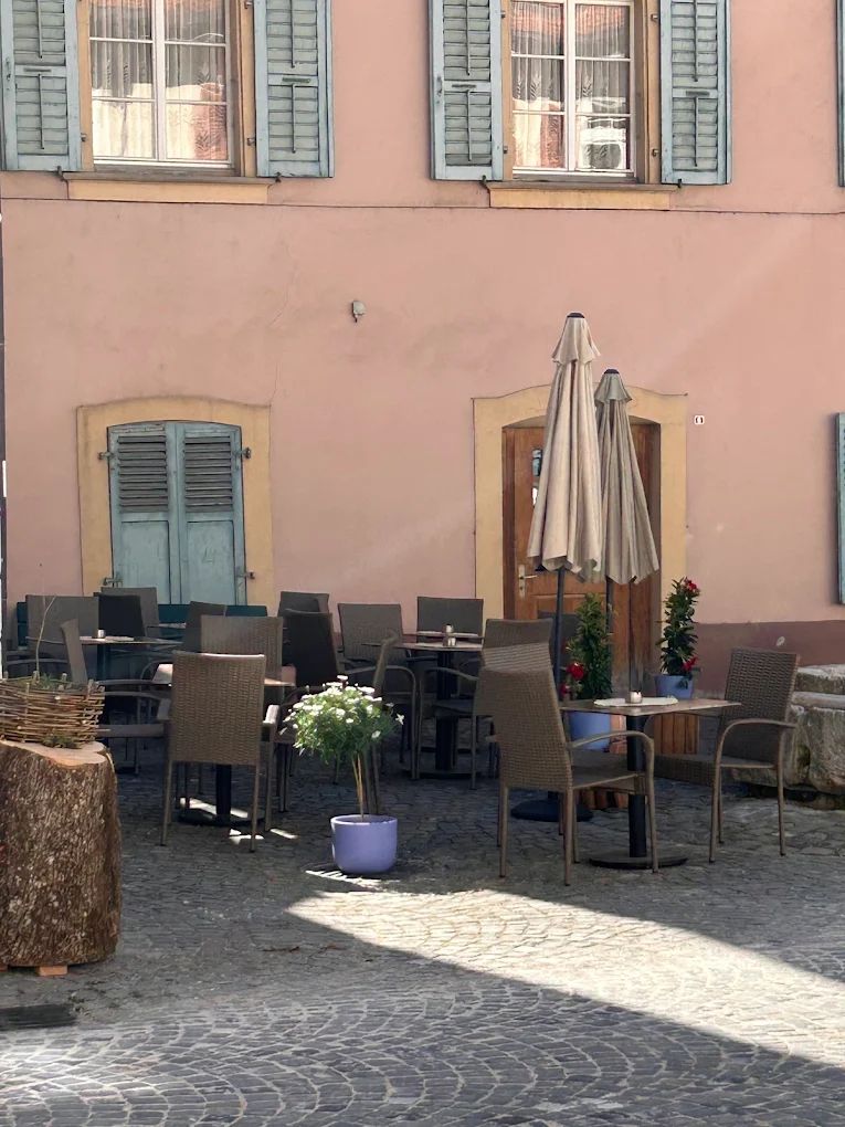 La terrasse, sur la place pavée, en face du bar